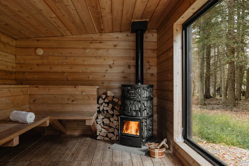 Puusauna, kiuas ja iso ikkuna metsään
